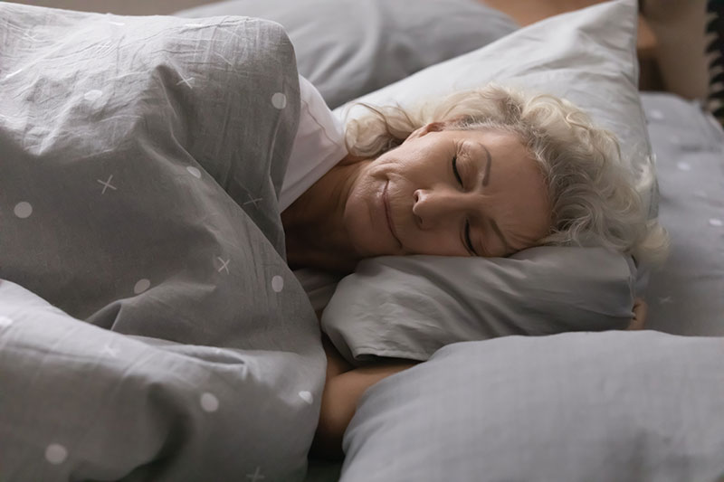 An Elderly Woman Sleeping Peacefully In Bed